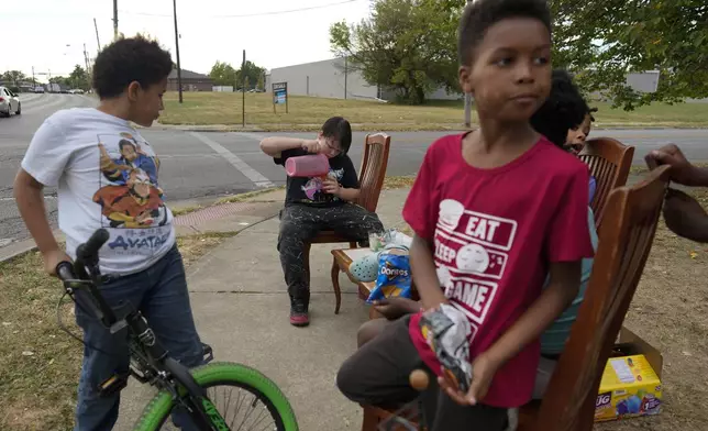 Neighborhood kids gather to sell Kool-Aid and chips, Tuesday, Sept. 17, 2024, in Springfield, Ohio. Some were kept home from school because of the bomb threats at their schools, and if that happens again, they plan to be at the corner with Kool-Aid and chips again tomorrow. (AP Photo/Carolyn Kaster)