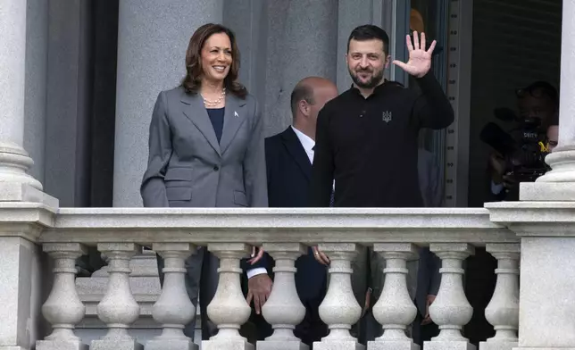 Vice President Kamala Harris accompanied by Ukraine's President Volodymyr Zelenskyy, waves from the balcony of the Eisenhower Executive Office Building on the White House complex in Washington, Thursday, Sept. 26, 2024. (AP Photo/Jose Luis Magana)