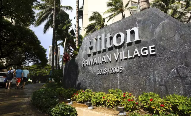 FILE - People walk into the Hilton Hawaiian Village resort in Honolulu, on Saturday, Sept. 4, 2021. (AP Photo/Caleb Jones, File)