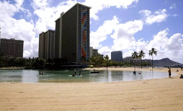 FILE - People swim in the lagoon in front of the Hilton Hawaiian Village resort in Honolulu on Saturday, Sept. 4, 2021. (AP Photo/Caleb Jones, File)