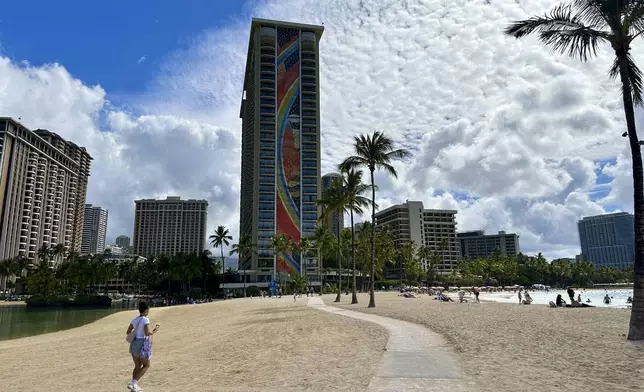 The Hilton Hawaiian Village's rainbow-covered building is seen from the beach on Tuesday, Sept. 24, 2024, in Honolulu. (AP Photo/Jennifer Sinco Kelleher)