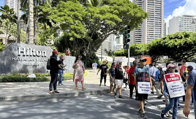 Hotel workers march outside the Hilton Hawaiian Village resort after going on strike on Tuesday, Sept. 24, 2024, in Honolulu. (AP Photo/Jennifer Sinco Kelleher)