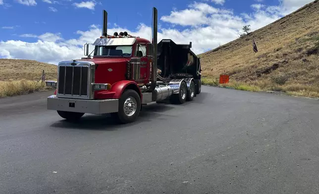 A truck exits from a temporary dump site in Lahaina, Hawaii on Thursday, July 18, 2024, where debris from last year's deadly fire is being stored. (AP Photo/Jennifer Sinco Kelleher)