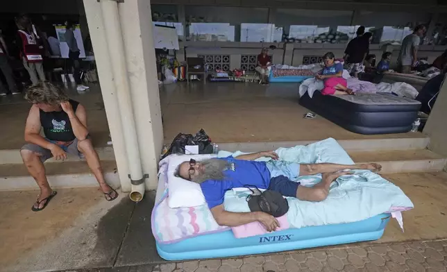 FILE - Thomas Leonard lies on an air mattress at an evacuation center at the War Memorial Gymnasium after his Lahaina apartment was destroyed by wildfire, Thursday, Aug. 10, 2023, in Wailuku, Hawaii. (AP Photo/Rick Bowmer, File)