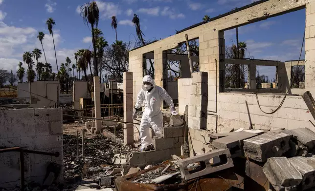 FILE - Rev. Ai Hironaka, resident minister of the Lahaina Hongwanji Mission, walks through the grounds of his temple and residence destroyed by wildfire, Thursday, Dec. 7, 2023, in Lahaina, Hawaii. (AP Photo/Lindsey Wasson, File)