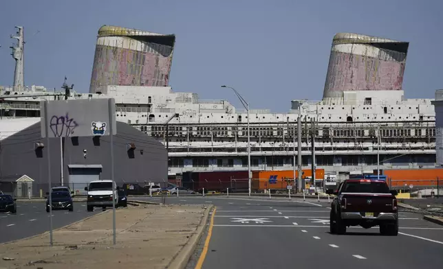 Vehicles move past the S.S. United States moored on the Delaware River in Philadelphia, Wednesday, Sept. 4, 2024. (AP Photo/Matt Rourke)