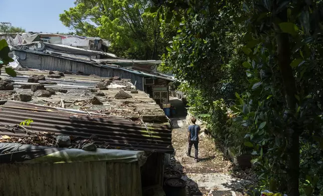 Villager Lo Yuet-ping walks through the Cha Kwo Ling village in east Kowloon, Hong Kong, Sunday, Aug. 25, 2024. (AP Photo/Chan Long Hei)