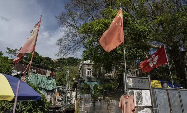 The flags of China and the Hong Kong Special Administrative Region (HKSAR) are flown at the entrance to the Cha Kwo Ling village in east Kowloon, Hong Kong, Sunday, Aug. 25, 2024. (AP Photo/Chan Long Hei)