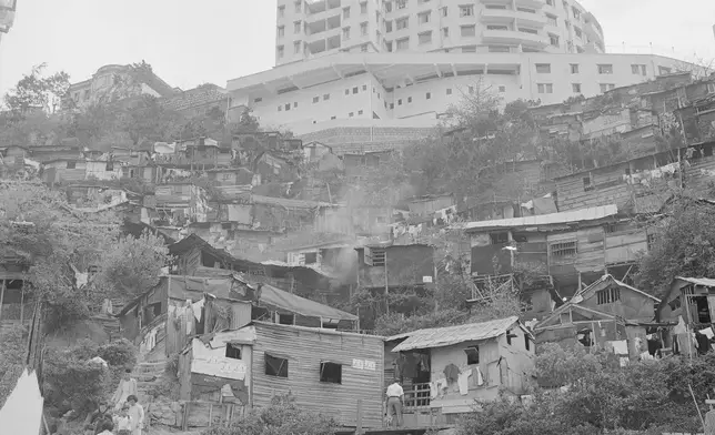 FILE- Perched high on a hill, a shiny new apartment house looks down upon a settlement of squatters' huts in the British crown colony of Hong Kong on May 16, 1956. (AP Photo/File)