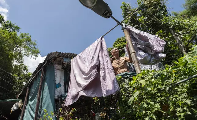 A elderly villager attends to his laundry at the Cha Kwo Ling Village in Hong Kong, Sunday, Aug. 25, 2024. (AP Photo/Chan Long Hei)