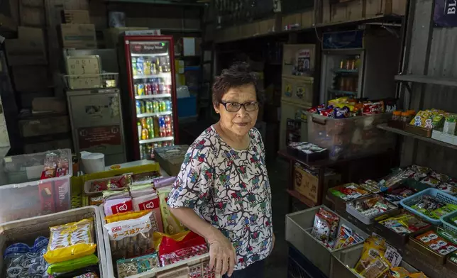 Teoh Bee Hua, a Malaysian who moved to Cha Kwo Ling after marrying a villager in 1973, poses for a photo at her grocery shop in the Cha Kwo Ling Village in Hong Kong, Sunday, Aug. 25, 2024. She has kept operating her grocery shop there even though she no longer lives in the village after a fire. (AP Photo/Chan Long Hei)