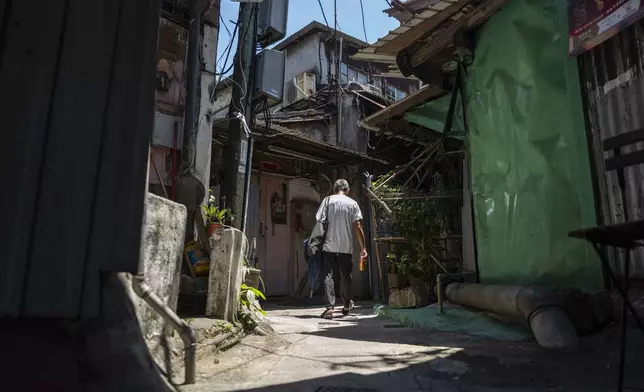 A villager walks through the Cha Kwo Ling village in east Kowloon, Hong Kong, Sunday, Aug. 25, 2024. (AP Photo/Chan Long Hei)