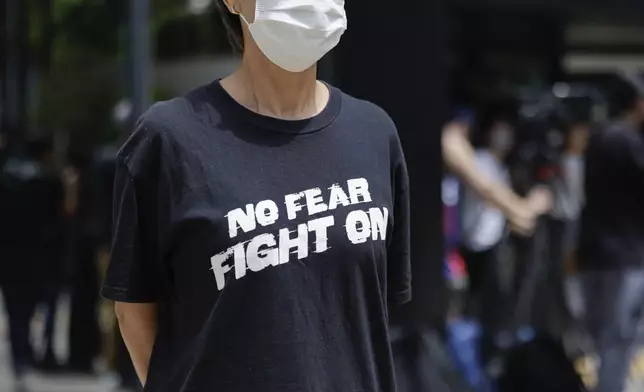 A member of the public stands outside the District Court in Wan Chai, Hong Kong, ahead of a sentencing hearing for two former Stand News editors convicted of sedition, Thursday, Sept. 26, 2024. (AP Photo/May James)