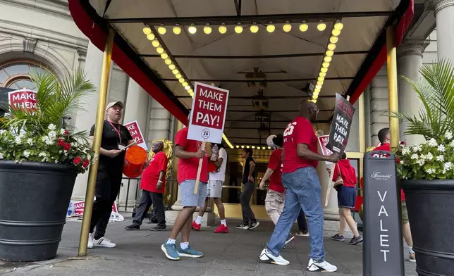 Hotel workers on strike chant and beat drums while picketing outside the Fairmont Copley Plaza hotel on Sunday, Sept. 1, 2024, in Boston. (AP Photo/Rodrique Ngowi)