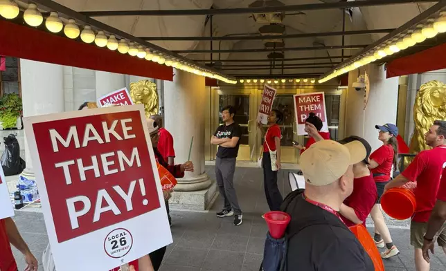 Hotel workers on strike chant and beat drums while picketing outside the Fairmont Copley Plaza hotel on Sunday, Sept. 1, 2024, in Boston. (AP Photo/Rodrique Ngowi)