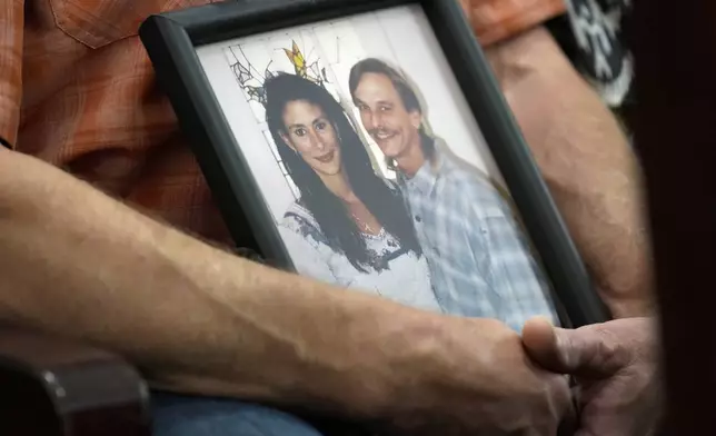 Family members of Dennis Tuttle and Rhogena Nicholas bring a photograph of the couple to the trial of retired Houston Police Department officer Gerald Goines Monday, Sept. 9, 2024 at Harris County Criminal Courthouse in Houston. Goines' trial on two felony murder charges in the January 2019 deaths of Tuttle and Nicholas began Monday. (Yi-Chin Lee/Houston Chronicle via AP)