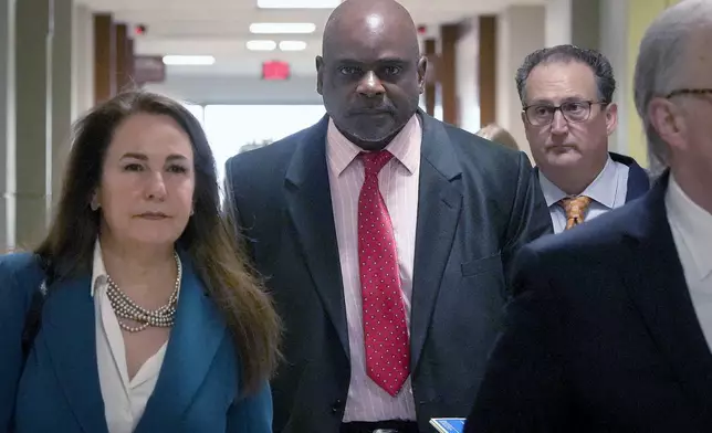 Retired Houston Police Department officer Gerald Goines, center, and his defense team arrive at 482nd District Court for his trial on two felony murder charges in the January 2019 deaths of Dennis Tuttle and Rhogena Nicholas Monday, Sept. 9, 2024 at Harris County Criminal Courthouse in Houston. (Yi-Chin Lee/Houston Chronicle via AP)