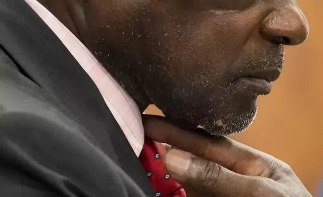 Retired Houston Police Department officer Gerald Goines adjusts his tie as his defense attorney is wrapping up the opening statement for his two felony murder charges in the January 2019 deaths of Dennis Tuttle and Rhogena Nicholas at the 482nd District Court Monday, Sept. 9, 2024 at Harris County Criminal Courthouse in Houston. (Yi-Chin Lee/Houston Chronicle via AP)