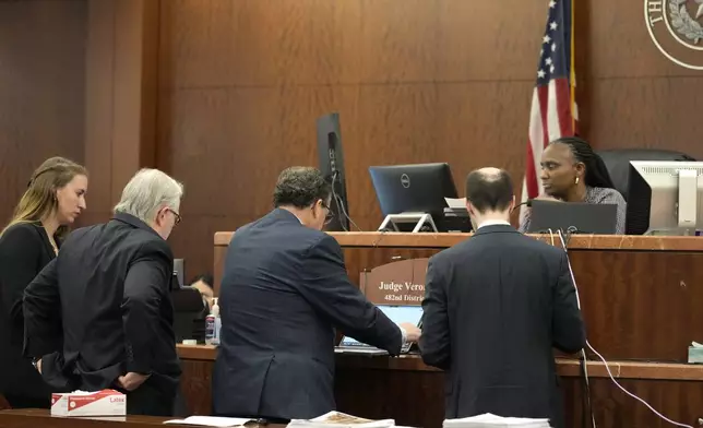 Attorneys gather with Judge Veronica M. Nelson in the case of former Houston police officer Gerald Goines in the 482nd District Court at the Harris County Criminal courthouse Tuesday, Sept. 24, 2024, in Houston. Goines faces two felony murder charges in the January 2019 deaths of Dennis Tuttle and Rhogena Nicholas. (Melissa Phillip/Houston Chronicle via AP)