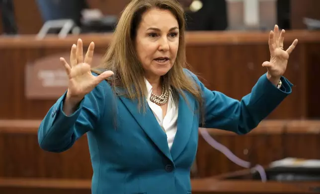 Defense attorney Nicole DeBorde Hochglaube puts her hands up as she tells the jury that Rhogena Nicholas was shot and killed by Houston police officers because she didn't listen to their command and didn't raise her hands when the officers entered her house during the opening statement at Monday, Sept. 9, 2024, at Harris County Criminal Courthouse in Houston. Retired HPD officer Gerald Goines was on trial for two felony murder charges in the January 2019 deaths of Dennis Tuttle and Nicholas during the Harding Street Raid. (Yi-Chin Lee/Houston Chronicle via AP)