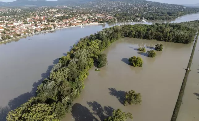 An aerial picture taken with a drone shows a flooded area and the swollen Danube River in Kisoroszi, Hungary, Wednesday, Sept. 18, 2024. (Gergely Janossy/MTI via AP)