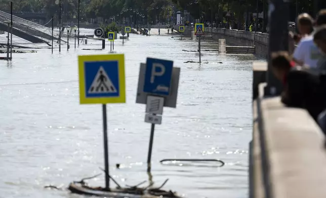 People watch the Danube river as it floods its banks, central Budapest, Hungary, Thursday, Sept. 19, 2024. (AP Photo/Denes Erdos)