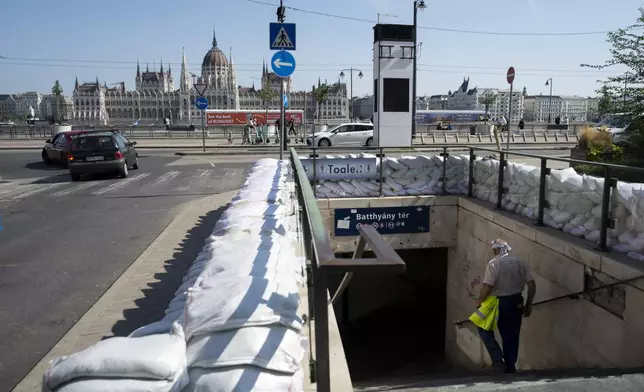 A workers walks down to a metro station protected by sandbags as the Danube river floods it's banks, central Budapest, Hungary, Thursday, Sept. 19, 2024. (AP Photo/Denes Erdos)