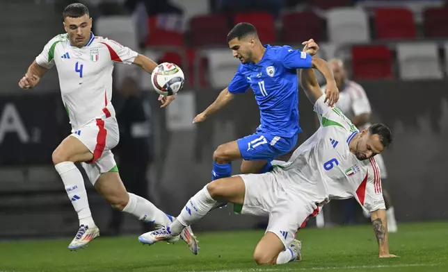 Israel's Liel Abada, centre, challenges for the ball with Italy's Federico Gatti, right, and Italy's Alessandro Buongiorno during the UEFA Nations League soccer match between Israel and Italy, at Bozsik Arena, in Budapest, Hungary, Monday, Sept. 9, 2024. (AP Photo/Denes Erdos)