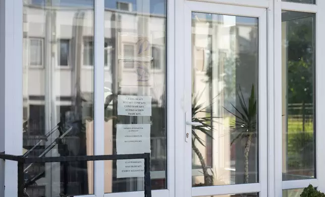 This photo shows a sign featuring the names of several companies on the door of a house where a Hungarian company that allegedly manufactured pagers that exploded in Lebanon and Syria is headquartered in Budapest, Thursday, Sept. 19, 2024. (AP Photo/Denes Erdos)