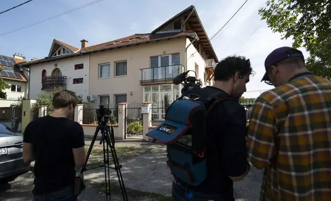 Local media works around a house where a Hungarian company that allegedly manufactured pagers that exploded in Lebanon and Syria, is headquartered in Budapest Wednesday, Sept. 18, 2024. (AP Photo/Denes Erdos)