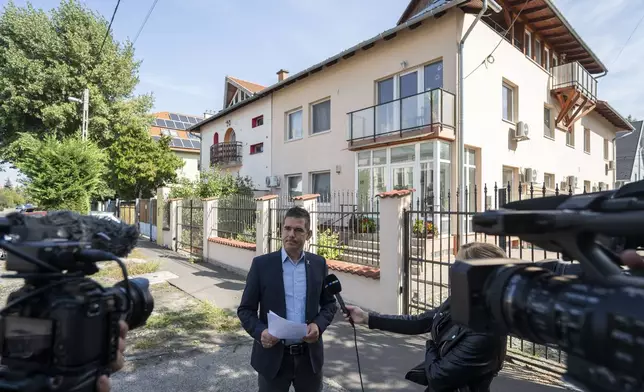 Előd Novak, a member of the National Assembly of Hungary, talks to the local media in front of a house where a Hungarian company that allegedly manufactured pagers that exploded in Lebanon and Syria, is headquartered in Budapest Wednesday, Sept. 18, 2024. (AP Photo/Denes Erdos)