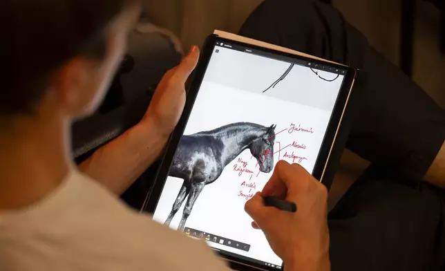 A first-year student takes notes during an anatomy lecture using a live horse from Dr. Peter Sotonyi, rector of the University of Veterinary Medicine in Budapest, Hungary, using a live horse, Monday, Sept 9. 2024. (AP Photo/Denes Erdos)