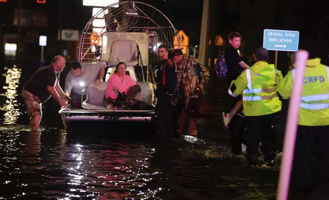 People and pets are rescued from flooded neighborhoods in the aftermath of Hurricane Helene on Friday, Sept. 27, 2024 in Crystal River, Fla. (Luis Santana/Tampa Bay Times via AP)