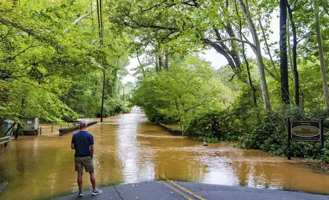 A patron looks at the flooding from Hurricane Helene in the Paces neighborhood, Friday, Sept 27, 2024, in Atlanta. (AP Photo/Jason Allen)