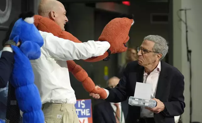 Eric Maskin, 2007 Nobel Laureate in Economics, right, presents an Ig Nobel award to a members of a team of researchers who who used chromatography to separate drunk and sober worms, during a performance at the Ig Nobel Prize ceremony at Massachusetts Institute of Technology, in Cambridge, Mass., Thursday, Sept. 12, 2024. (AP Photo/Steven Senne)