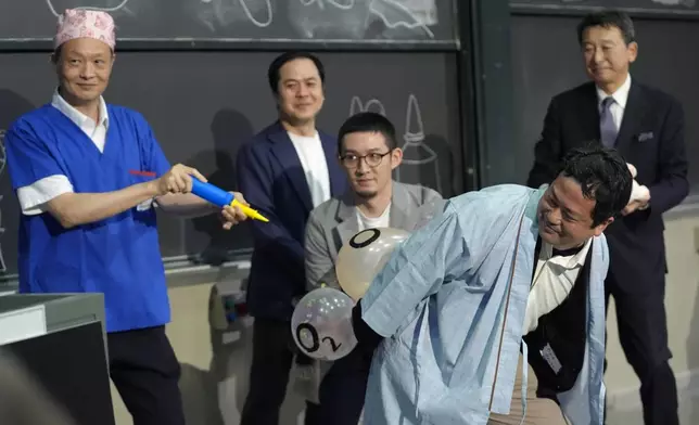 A team of researchers perform a demonstration during a performance showing that many mammals are capable of breathing through their anus while accepting the 2024 Ig Nobel prize in physiology at the Ig Nobel Prize ceremony at Massachusetts Institute of Technology, in Cambridge, Mass., Thursday, Sept. 12, 2024. (AP Photo/Steven Senne)