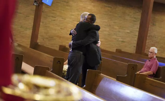 Carl Ruby, pastor at Central Christian Church, hugs Viles Dorsainvil during service, on Sunday, Sept. 15, 2024, in Springfield, Ohio. (AP Photo/Jessie Wardarski)