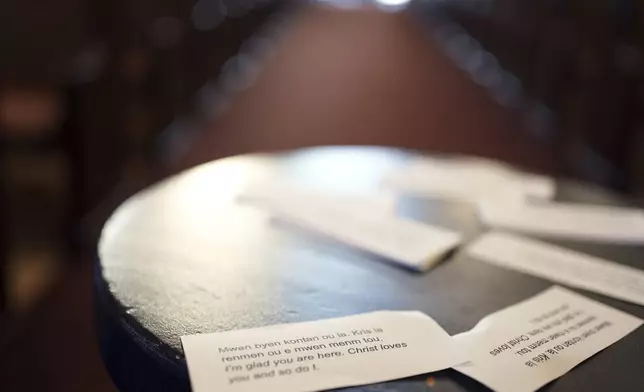 Cards printed in both Creole and English display a message of support for Haitians that reads, "I'm glad you are here. Christ loves you and so do I," near the altar at Central Christ Church after a service Sunday, Sept. 15, 2024, in Springfield, Ohio. (AP Photo/Luis Andres Henao)