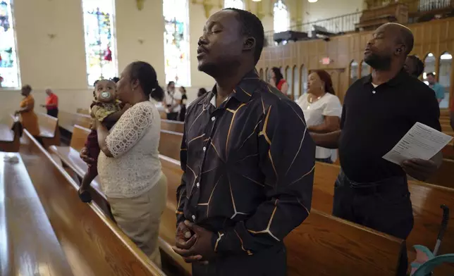 Congregants worship at St Raphael Catholic church in Springfield, Ohio, Sunday, Sept. 15, 2024. (AP Photo/Jessie Wardarski)