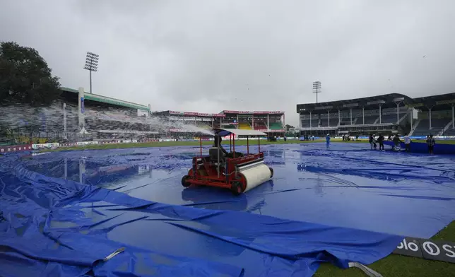 Groundsmen remove water from the outfield before the start of the second cricket test match between Bangladesh and India at the Green Park stadium in Kanpur, India, Friday, Sept. 27, 2024. (AP Photo/Ajit Solanki)