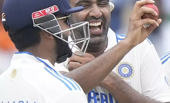 India's Ravichandran Ashwin, right, shows the ball in his hand as he celebrates his 5-wicket haul on the fourth day of the first cricket test match between India and Bangladesh, in Chennai, India, Sunday, Sept. 22, 2024. (AP Photo/Mahesh Kumar A.)