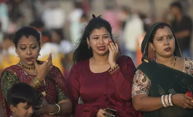 Devotees react as they watch the immersion of an idol of elephant-headed Hindu god Ganesha in the Arabian Sea, during the ten days long Ganesh Chaturthi festival in Mumbai, India, Sunday, Sept. 8, 2024. (AP Photo/Rafiq Maqbool)