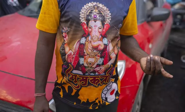 A devotee wears a t-shirt with the picture elephant-headed Hindu god Ganesha during Ganesh Chaturthi festival celebrations in Mumbai, India, Saturday, Sept. 7, 2024. (AP Photo/Rafiq Maqbool)