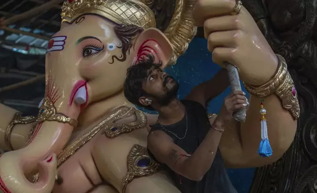 An artist applies finishing touches to an idol of the elephant-headed Hindu god Ganesha inside a workshop ahead of Ganesh Chaturthi festival in Mumbai , India, Wednesday, Sept. 4, 2024. (AP Photo/Rafiq Maqbool)