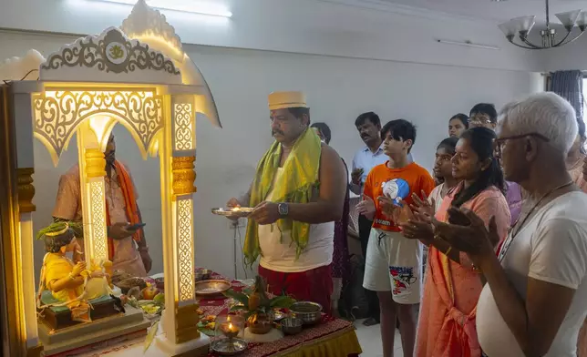 Kunal Patil, along with his family and relatives offer prayers to an eco-friendly idol of the elephant-headed Hindu god Ganesha at his residence during Ganesh Chaturthi festival celebrations in Mumbai, India, Saturday, Sept. 7, 2024. (AP Photo/Rafiq Maqbool)