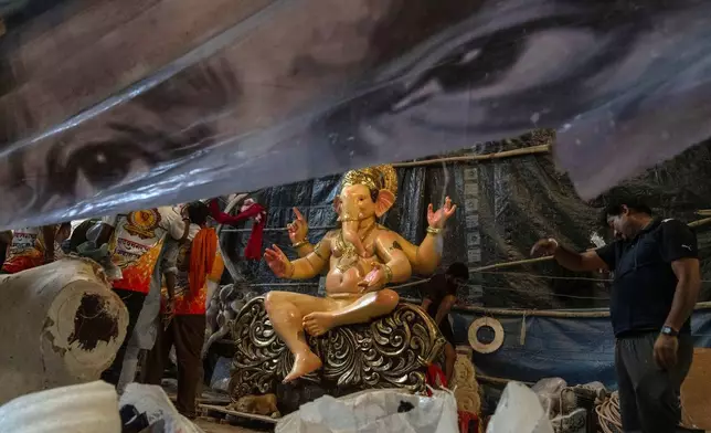 Workers complete an idol of the elephant-headed Hindu god Ganesha inside a workshop ahead of Ganesh Chaturthi festival in Mumbai, India, Wednesday, Sept. 4, 2024. (AP Photo/Rafiq Maqbool)