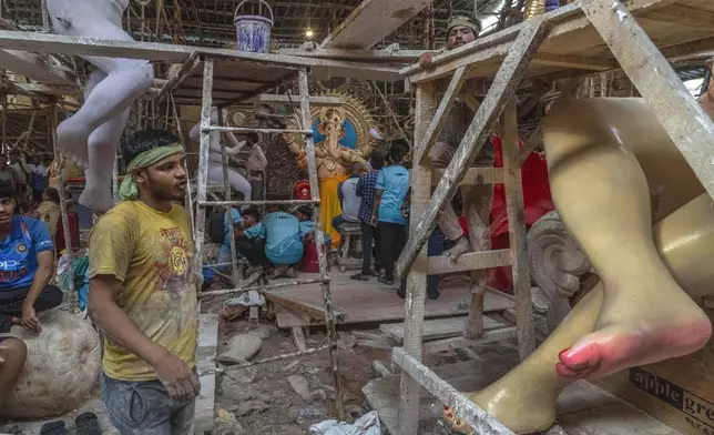 Workers work on an idol of the elephant-headed Hindu god Ganesha inside a workshop ahead of Ganesh Chaturthi festival in Mumbai, India, Wednesday, Sept. 4, 2024. (AP Photo/Rafiq Maqbool)