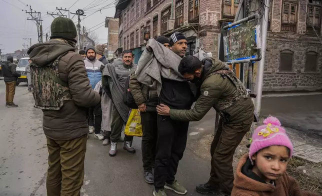 A child looks on as Indian policemen frisk Kashmiri pedestrians during a surprise security check in Srinagar, Indian controlled Kashmir, Monday, Jan. 9, 2023. (AP Photo/Mukhtar Khan, File)