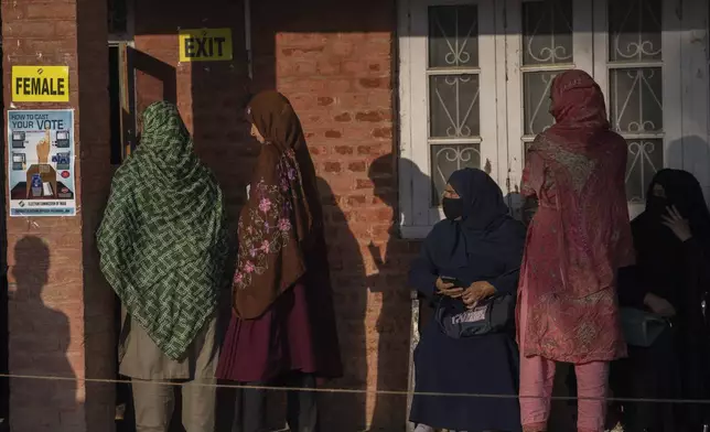 Kashmiri women queue up at a polling booth to cast their vote in Marval, south of Srinagar, Indian controlled Kashmir, Wednesday, Sept. 18, 2024. (AP Photo/Dar Yasin)