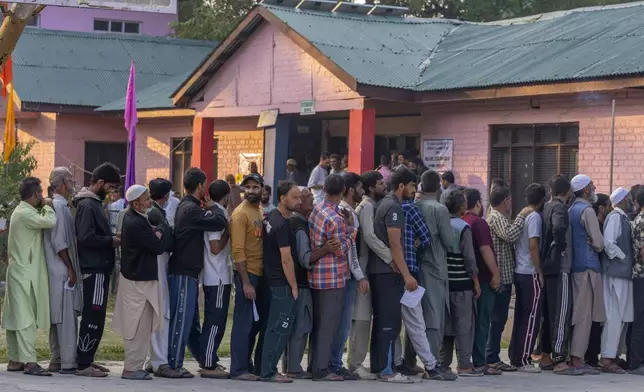 Kashmiri's queue up at a polling booth to cast their vote during the second phase of the assembly election in the outskirts of Srinagar, Indian controlled Kashmir, Wednesday, Sept. 25, 2024. (AP Photo/Dar Yasin)